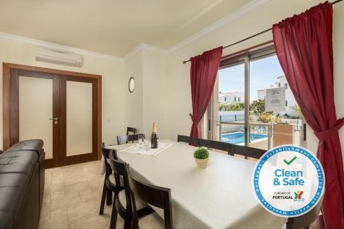 a dining room with a table and a couch at Moradia Ricardo - Praia da Gale in Albufeira