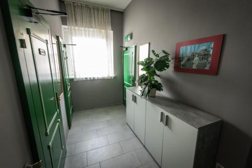 un bagno con porta verde e una pianta su un bancone di Hotel Am Limes a Enns