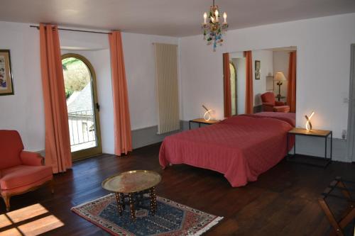 een slaapkamer met een bed, een tafel en een stoel bij Les Distinguées - L Ayral in Gaillac-dʼAveyron
