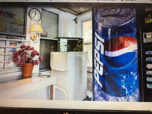 a vending machine with a can of soda in a room at Monmouth OYO in Neptune City