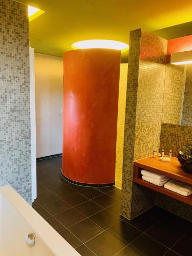 a bathroom with a red column in the middle at The Seven Hotel in Esch-sur-Alzette