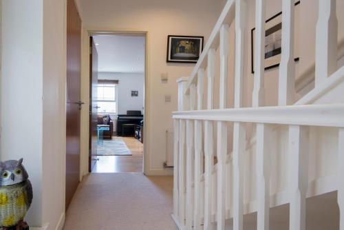 a hallway with a white staircase with a cat in a vase at Modern, 2 Bdrm House with Parking Sleeps 6 Brighton Town Centre, North Laine in Brighton & Hove