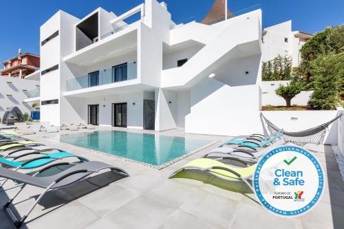 a villa with a swimming pool and lounge chairs at Luxury 47 in Albufeira