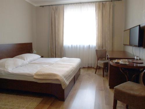 1 dormitorio con cama, escritorio y ventana en Motel Zacisze, en Łomża