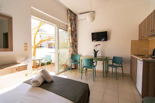a room with a bed and a table with chairs at Nicole Rooms in Palaiochóra
