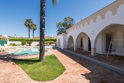 a villa with a swimming pool and palm trees at Villa near the beach and Lagos Marina #1868 in Lagos