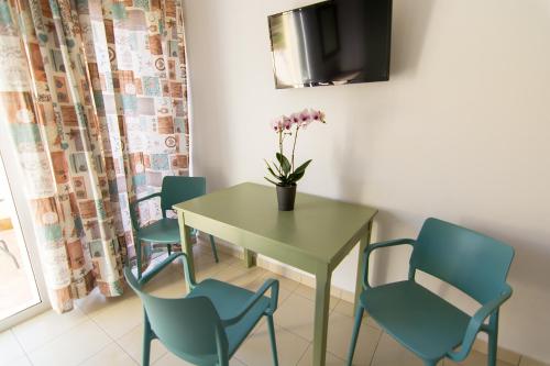 a dining room with a table and four chairs at Nicole Rooms in Palaiochóra