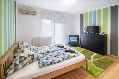 a bedroom with a bed and a tv in it at Lux Apartmanok in Hajdúszoboszló