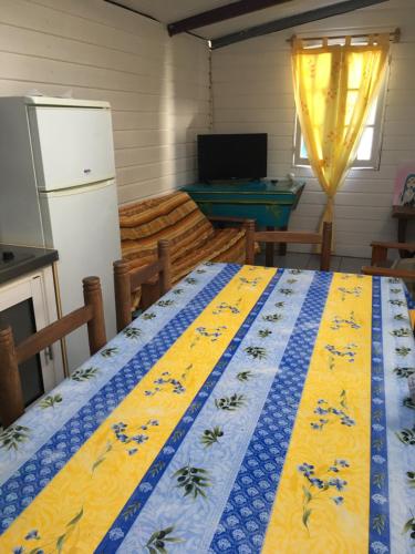 a kitchen with a blue and yellow quilt on a bed at LE CALBANON in Cilaos