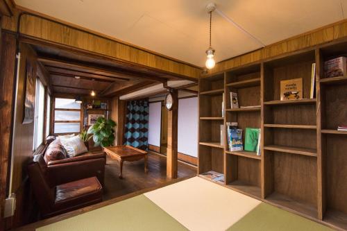a living room with a couch and bookshelves at DOT DOT HOUSE NAGANO Traditional Japanese house - Vacation STAY 82102 NAGANO - Vacation STAY 82102 in Nagano