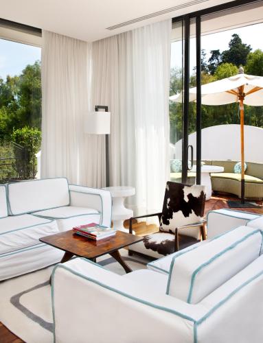 a living room with white furniture and large windows at Condesa df, Mexico City, a Member of Design Hotels in Mexico City