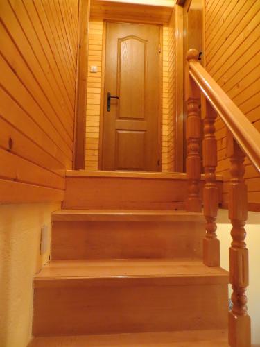 a wooden staircase with a door in a house at Rooms and Bungalows Sreten Žugić in Žabljak
