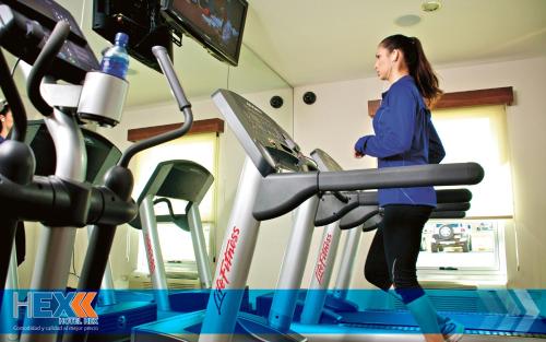 a woman walking on a treadmill in a gym at Hotel Hex Estelí in Estelí
