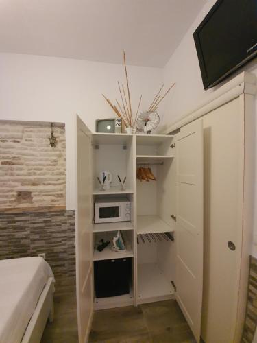 een kleine kamer met een bed en een magnetron bij Recuerdos de la Abuela in Sevilla