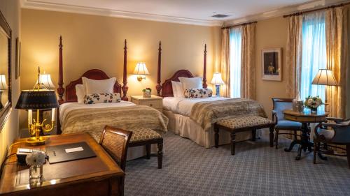 um quarto de hotel com duas camas e uma secretária em Delamar Southport em Southport