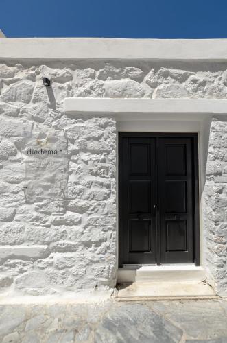 a black door on a white brick building at Diadema Apartments in the Town in Naxos Chora
