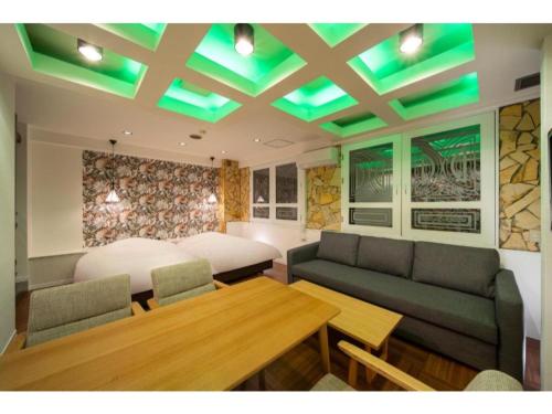 a living room with a bed and a table at Royal Hotel Uohachi Bettei - Vacation STAY 81418 in Ogaki