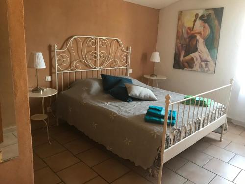 Un dormitorio con una cama y un cuadro en la pared. en La Bastide de l'Olivier, en Flassan