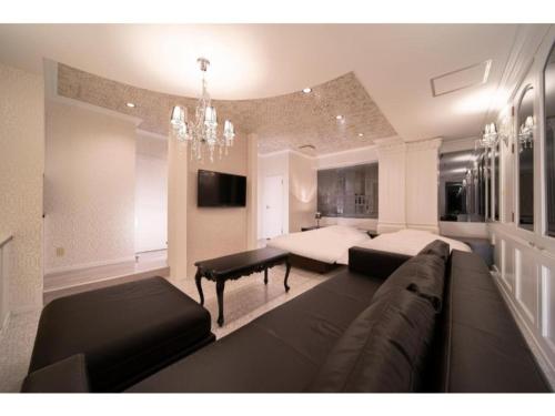 a living room with a couch and a bed at Royal Hotel Uohachi Bettei - Vacation STAY 81419 in Ogaki