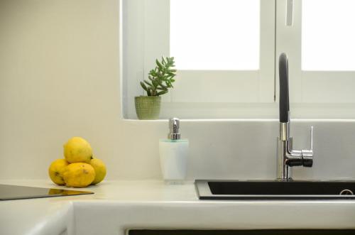 a kitchen counter with a sink and some fruit at Diadema Apartments in the Town in Naxos Chora