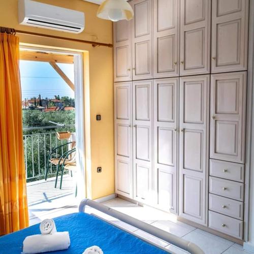 a room with a bath tub and a large window at Alexandra Apartments in Stoupa