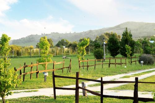 a field with a fence and a dirt road at Cabañas Colinas Serranas in Tandil