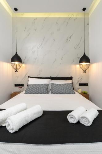 a bedroom with a large white bed with two pillows at Diadema Apartments in the Town in Naxos Chora