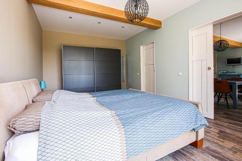 a bedroom with a large bed with a blue comforter at AenBetje in Goedereede