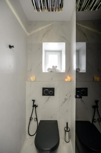 a bathroom with a black toilet and a window at Diadema Apartments in the Town in Naxos Chora