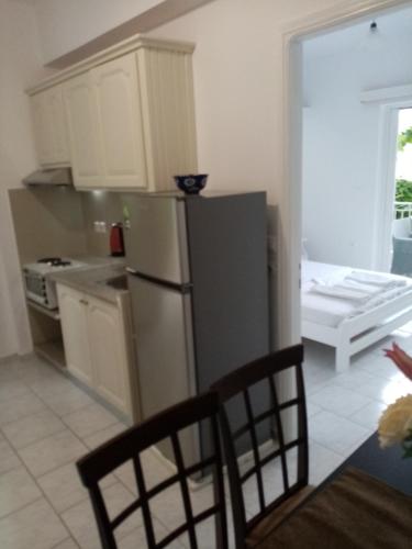 a kitchen with a refrigerator and a table and chairs at Steven in Vasiliki