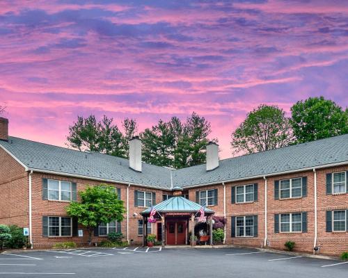 a large brick building with a pink sky at Brandywine River Hotel in Chadds Ford