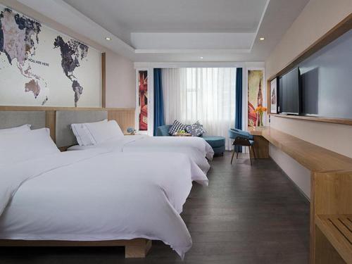 um quarto de hotel com duas camas e uma televisão de ecrã plano em Kyriad Hotel Dongguan Dalingshan South Road em Dongguan