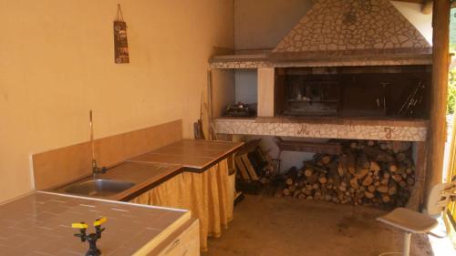 a kitchen with a stove and a counter with a fireplace at Chalet Del Pozzo in Luco neʼ Marsi