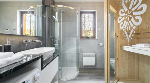La salle de bains est pourvue d'une douche en verre et d'un lavabo. dans l'établissement Czeremcha - Ostoja Bukowinki, à Jaworki