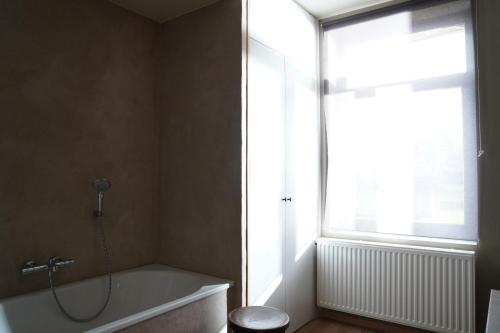 ヘントにあるWell-situated and Comfortable Homeのバスタブと窓のあるバスルーム