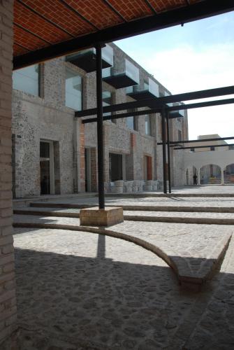 a building with a bench in the middle of a courtyard at La Purificadora, Puebla, a Member of Design Hotels in Puebla