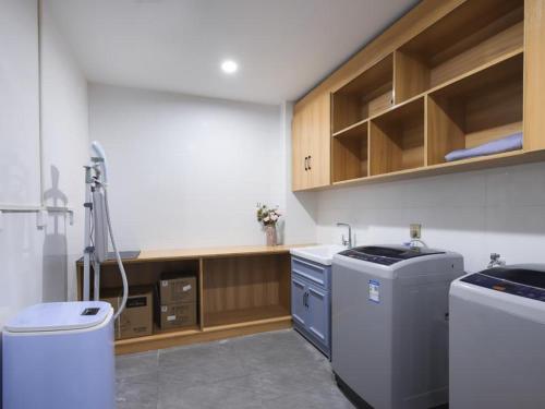 Il comprend une cuisine équipée d'une cuisinière et d'un lave-linge/sèche-linge. dans l'établissement Kyriad Hotel Bozhou Lixin Wanbei Mall, à Chundian