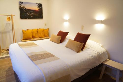 1 dormitorio con 1 cama blanca grande con almohadas de color naranja en Well-situated and Comfortable Home, en Gante