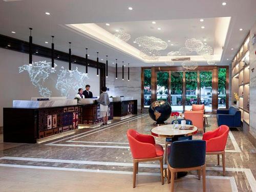 un vestíbulo de un hotel con mesa y sillas en KyriadChina Guilin Railway Station MixC, en Guilin