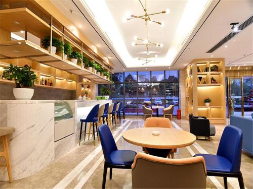 a restaurant with tables and chairs and a bar at KyriadChina Changsha the zone of environment protection hotel in Changsha