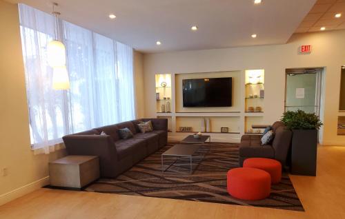 a living room with a couch and a flat screen tv at Days Inn by Wyndham Titusville Kennedy Space Center in Titusville