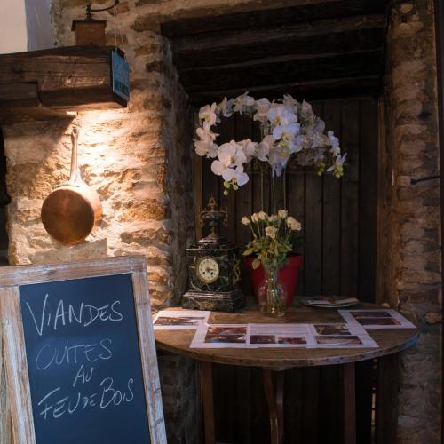 a table with a sign and flowers on it at Auberge du Renard'eau in Bèze