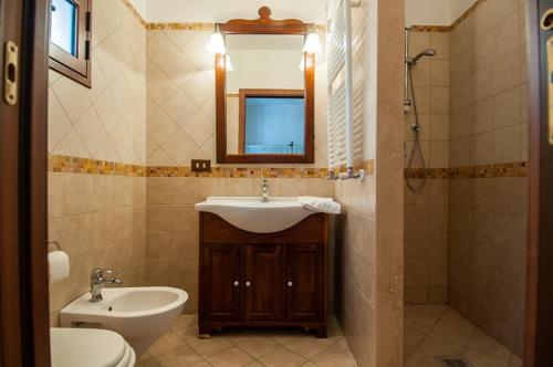 uma casa de banho com um lavatório, um WC e um espelho. em Dimora Ginnasio em Monopoli