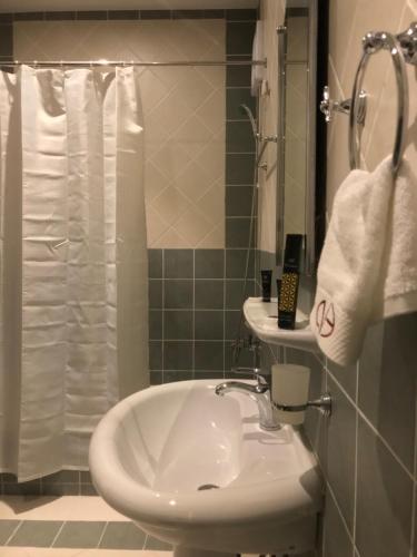 a bathroom with a white sink and a shower at Najran Hotel in Najran