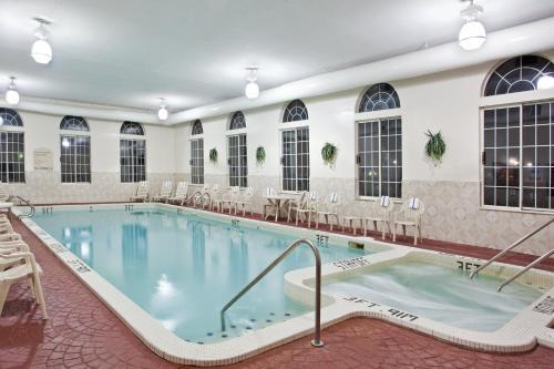 a large pool in a hotel with tables and chairs at Holiday Inn Express Birch Run-Frankenmuth Area by IHG in Birch Run