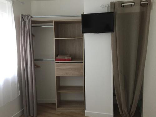 a refrigerator with a television on top of it at La Villa des Remparts in Lisieux