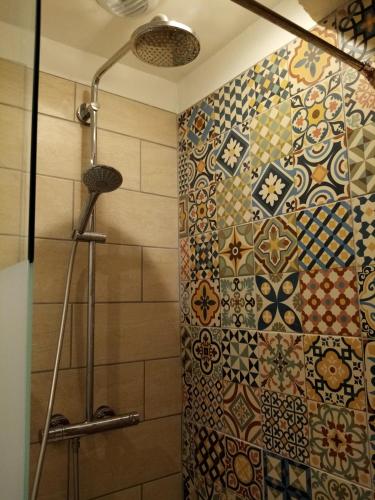 La salle de bains est pourvue d'une douche avec rideau de douche en mosaïque. dans l'établissement La Villa des Remparts, à Lisieux