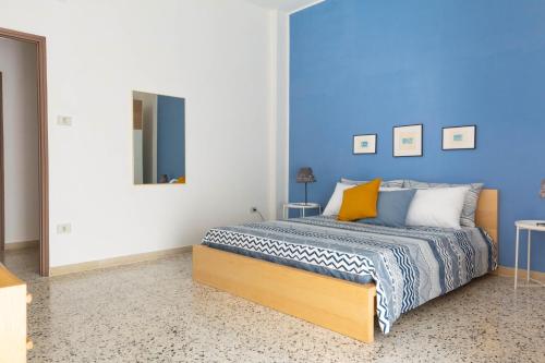 1 dormitorio con 1 cama con pared azul en Gaia14, en Salerno
