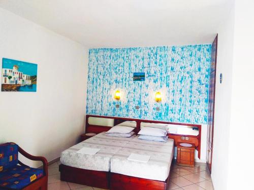 um quarto com uma cama e uma parede azul em Studios Maria em Chrysi Ammoudia