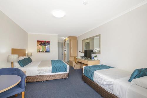 a hotel room with two beds and a desk at Best Western Airport 85 Motel in Brisbane